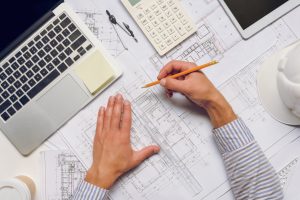 a man's hands on a blueprint